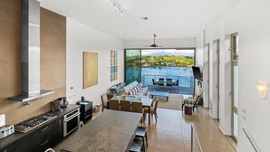 A spacious kitchen with a large island, a dining area with a view of the ocean, and a modern interior design. - Modern Oceanfront Resort Living. Luxury Oceanfront Bedroom Suites. Sleeps 10! (Lihue)