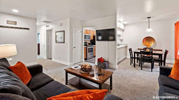 Un salon moderne comprenant un canapé, une table basse et un coin repas avec une table et des chaises.