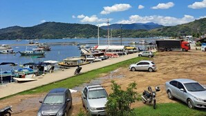 A marina with boats, a truck, and cars parked on the shore. - Paraty house near historic center (paraty)