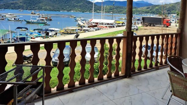 A covered balcony with a view of boats and a dock. - Paraty house near historic center (paraty)