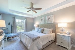 A bedroom with a bed, bedside tables, a chair, a ceiling fan, and artwork on the wall. - Minutes To Naples Top Beaches From This Beautiful Lake View Home. (Naples)
