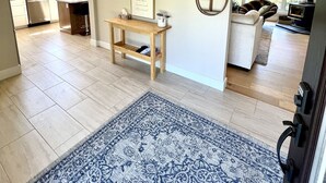 A spacious living area with a wooden ceiling, a blue patterned rug, a small wooden table, and a sofa. - 5-Bedroom Executive Lakefront Retreat Sleeping 12- Relax, Recharge and Reconnect (Greater Sudbury)