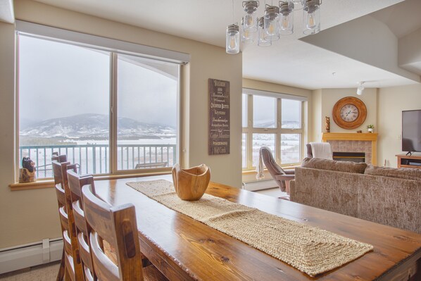 Relax in this serene living space with a large dining table, comfortable seating area, and a fireplace.