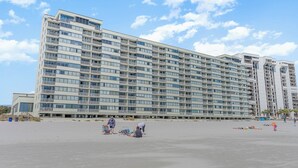 Ein großes Hotel mit mehreren Etagen und Balkonen in Strandnähe.