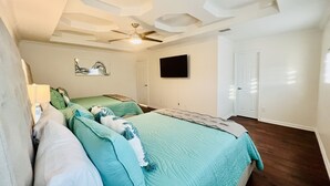 A bedroom with a bed, a ceiling fan, a TV mounted on the wall, and a door. - 🏡 Home sweet Home in the ❤️of McAllen (McAllen)