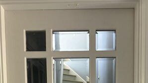 A white door with a glass panel and a keyhole lock.