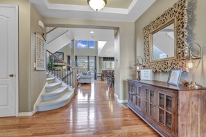A spacious hallway with a wooden floor, a staircase with a railing, and a large ornate mirror on the right. - 4,000 sqft Cozy Mtn Home! Huge Game Room! Family Friendly Pool Table (Arvada)