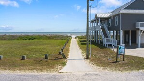 A beachfront property with a pathway leading to a building with multiple balconies. - Sweetheart savings! 3 min walk to Beach, Ocean View, WIFI, King 🛏 (Crystal Beach)