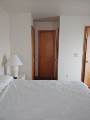 Simple, functional room with a single bed and a table lamp.