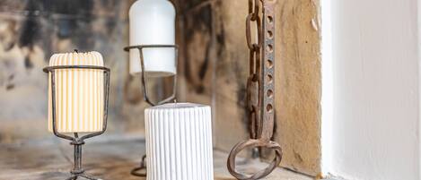 Tre candelabri su un davanzale di pietra vicino a una parete.