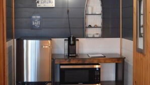 A compact kitchen with a stainless steel refrigerator, a microwave, and a small sink. A sign on the wall reads "FISHING Bait." - Columbia Point Resort (Kettle Falls)