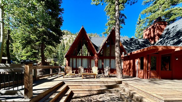 A wooden deck with Adirondack chairs, a wooden staircase, and a red building with large windows. - Snowy Paws Alpine Meadows - Ski Shuttle- Dog OK - Close to Slopes - Amazing Views (Olympic Valley)