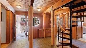 A wooden interior with a staircase, a door leading outside, and a window with a view of the outside. - Snowy Paws Alpine Meadows - Ski Shuttle- Dog OK - Close to Slopes - Amazing Views (Olympic Valley)