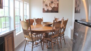 A dining area with a wooden table and chairs, a chandelier, and a painting of flowers on the wall. - Edward House, on 7 acres, not far from Notre Dame & Golf Course (Walkerton)