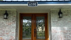 A double wooden door with glass panels and a number sign above it. - 4BR/3BA on a Golf Course close to Beach, Casinos & Downtown Ocean Springs! (Ocean Springs)