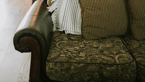 A cozy living room with a patterned sofa, a white throw blanket, and a patterned rug. - 4BR/3BA on a Golf Course close to Beach, Casinos & Downtown Ocean Springs! (Ocean Springs)