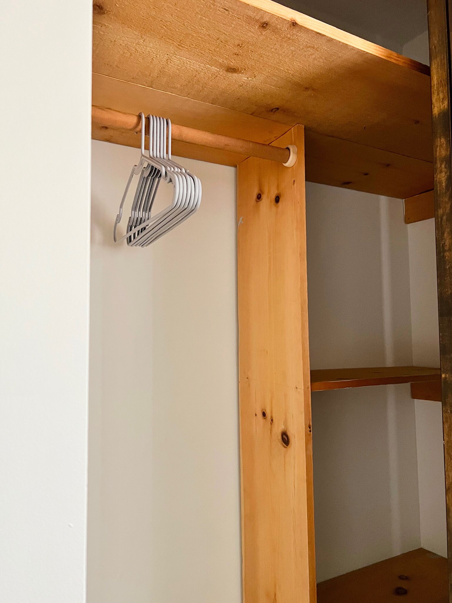 Een houten balkenconstructie met een metalen rek eraan bevestigd.