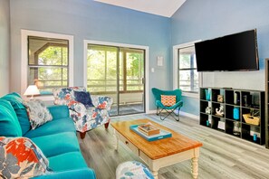 Relax in this stylish living room with a comfortable sofa, flat-screen TV, and beautiful views of the surrounding greenery.