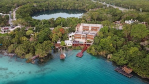 An aerial view of a coastal resort with a large building, a dock, and clear turquoise waters. - Amainah Bacalar Hotel Boutique - Adults Only (Bacalar)