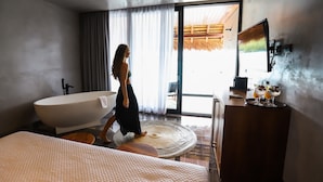 A modern bathroom with a freestanding bathtub, a large mirror, and a vanity with a tray of drinks. - Amainah Bacalar Hotel Boutique - Adults Only (Bacalar)