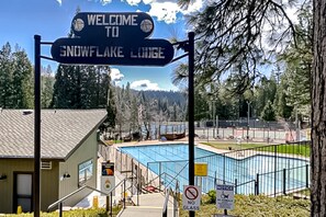 A welcome sign for Snowflake Lodge, a pool area, and a no glass sign.