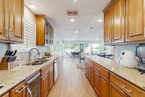 Enjoy cooking in this well-lit kitchen with a central island and large windows offering a view of the outdoors.