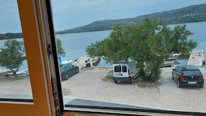 Vista desde una habitación con ventana que da a un estacionamiento junto a un lago.