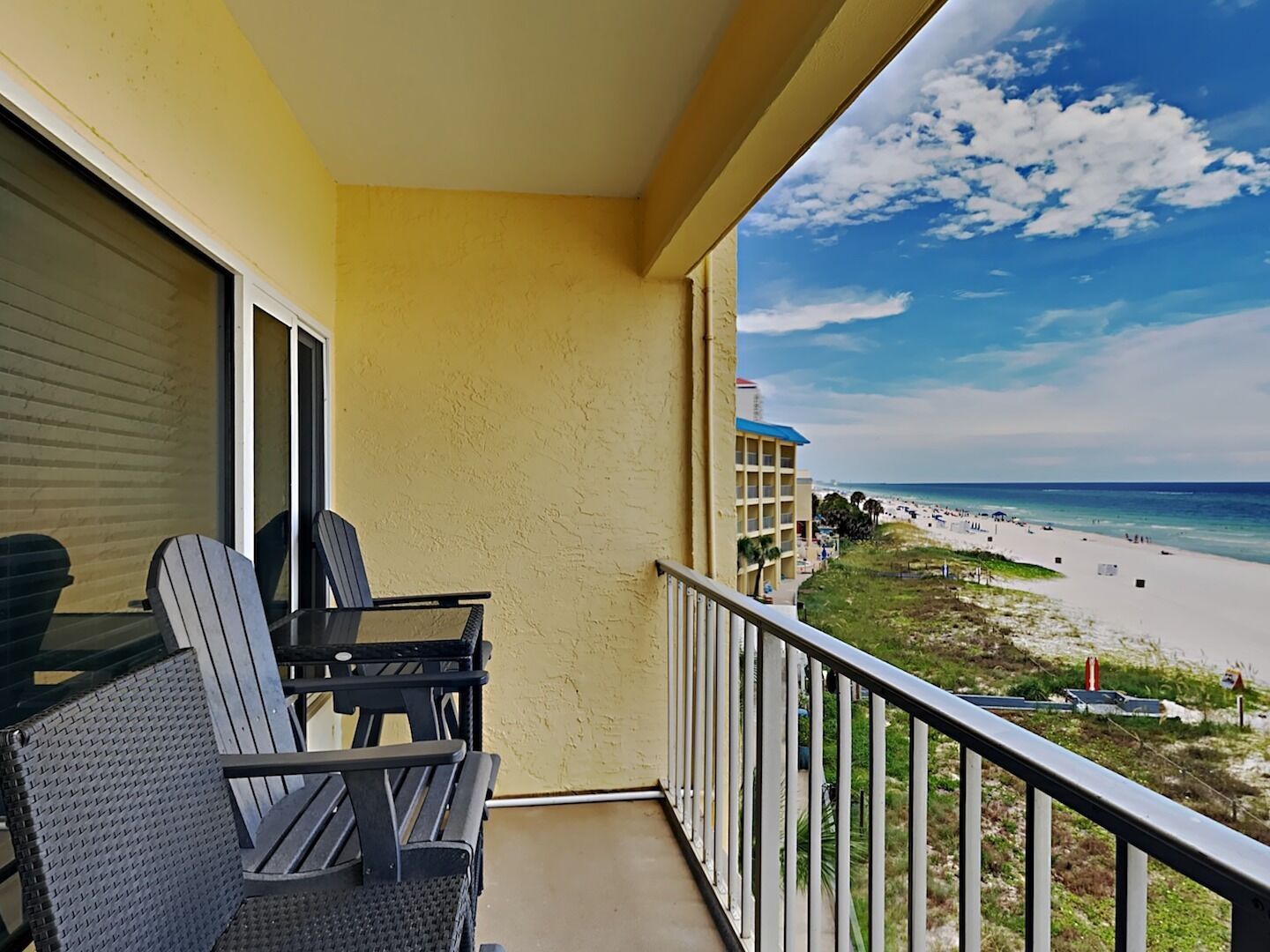 A balcony with a view of a beach and ocean.