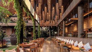 A restaurant with wooden tables and chairs, hanging lights, and greenery. - GDAS Bali Health and Wellness Resort (Ubud)