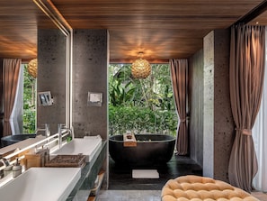 Ein modernes Badezimmer mit einer großen Badewanne, einem Doppelwaschbecken und einem Spiegel.