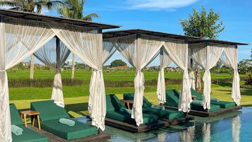 Una piscina al aire libre, sillones reclinables de piscina