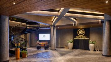 Un'ampia hall con una scala a chiocciola, una reception e un grande cartello per GdAS Bali Health & Wellness Resort.