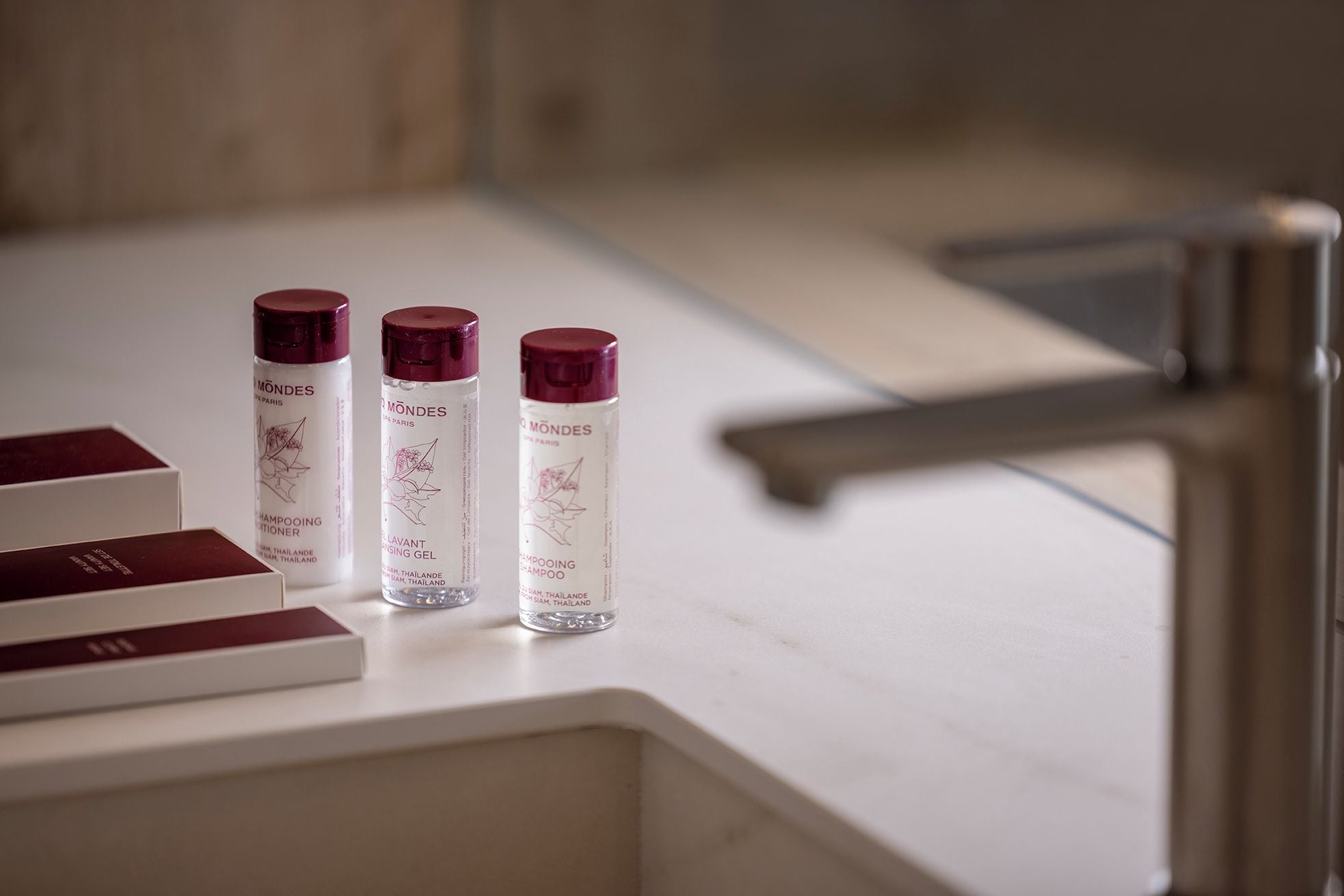 Drie flessen shampoo op een witte aanrecht.