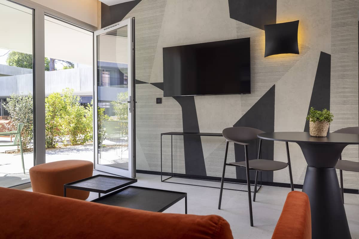 A modern interior with a sofa, a small table, and a TV mounted on the wall.