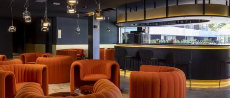 A modern bar area with orange seating and a curved counter.