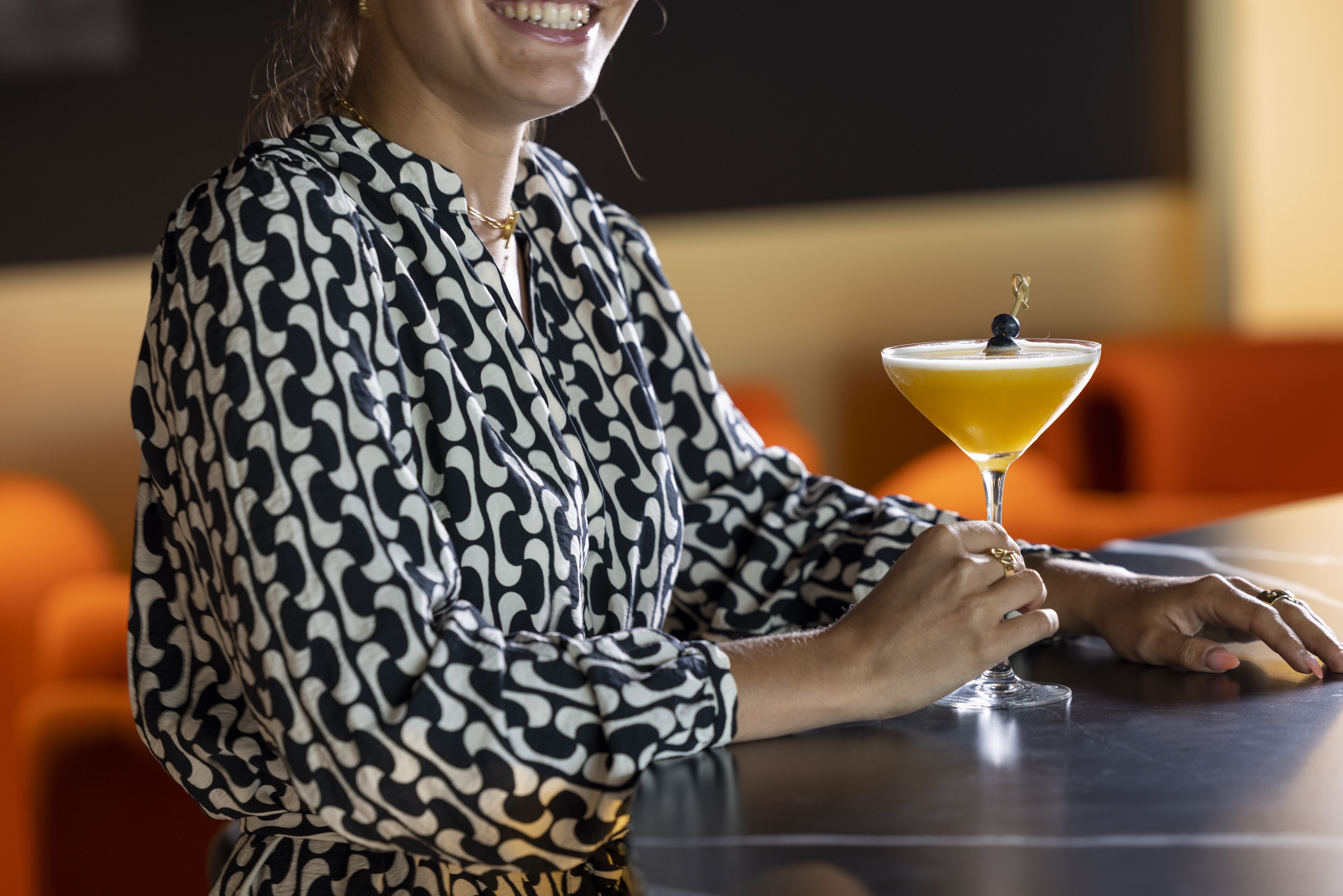 Une personne assise à une table, avec un verre de martini.