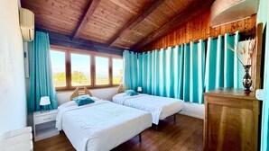 A room with two beds, wooden ceiling, large windows, and a wooden cabinet. - Hotel New Genziana (Altavilla Vicentina)