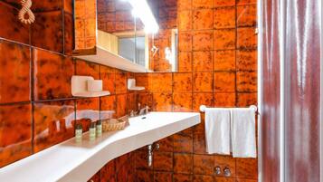 Een badkamer met een wit wastafelmeubel, spiegel en handdoekhouder.