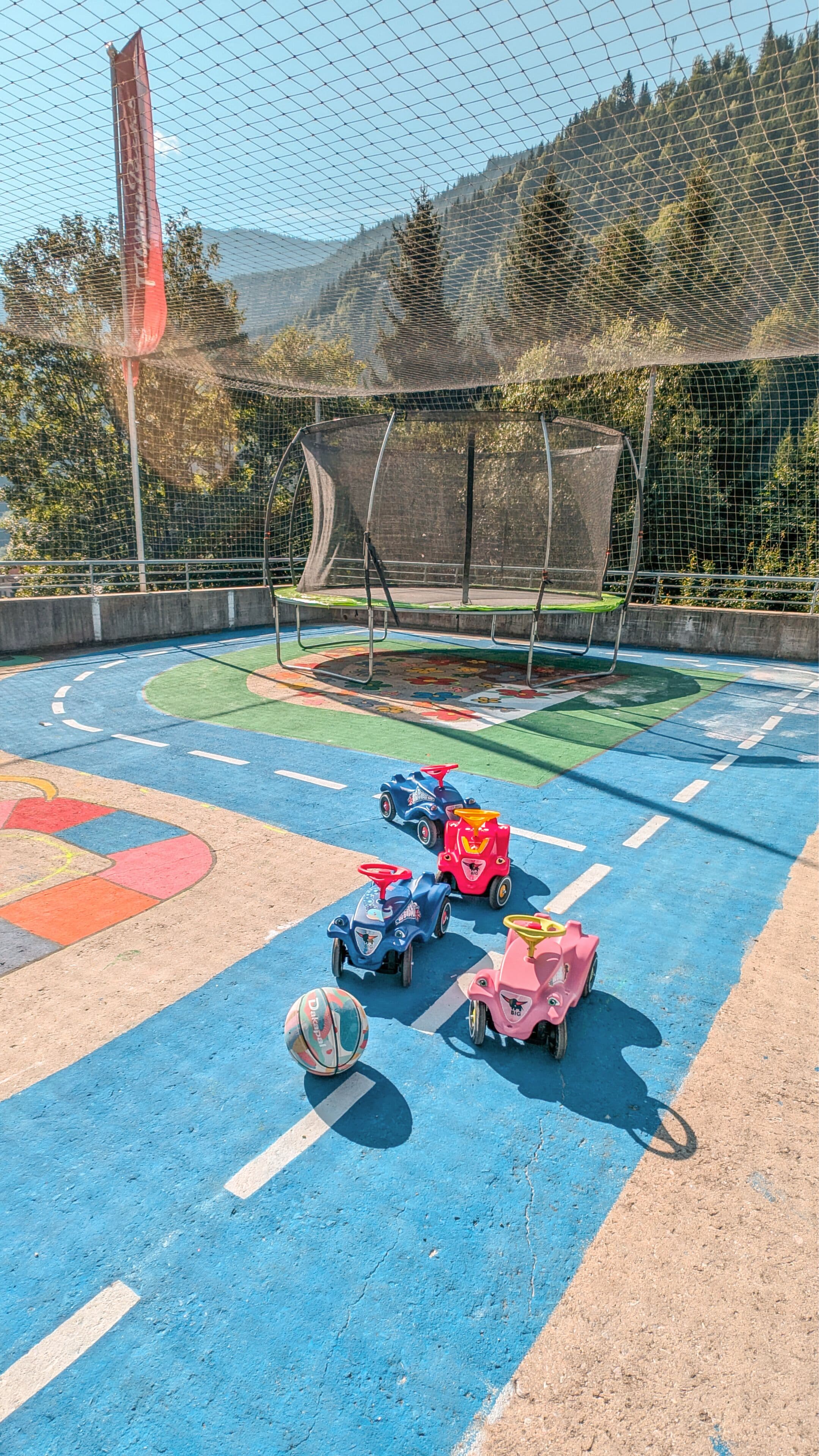 Une aire de jeux avec des équipements colorés et un ballon de foot.