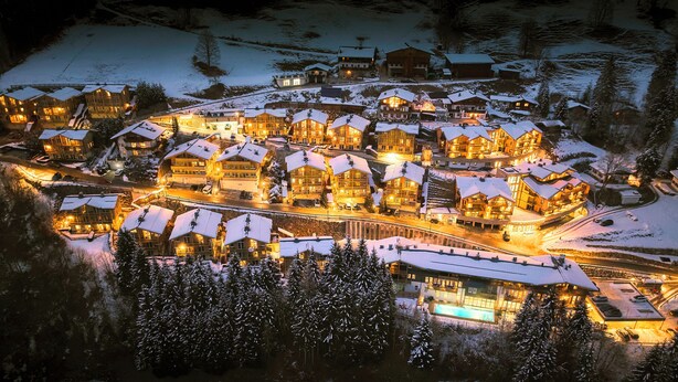 A snow-covered resort with multiple buildings, a swimming pool, and a ski lift. - AlpenParks Ferienresort Rehrenberg (Viehhofen)