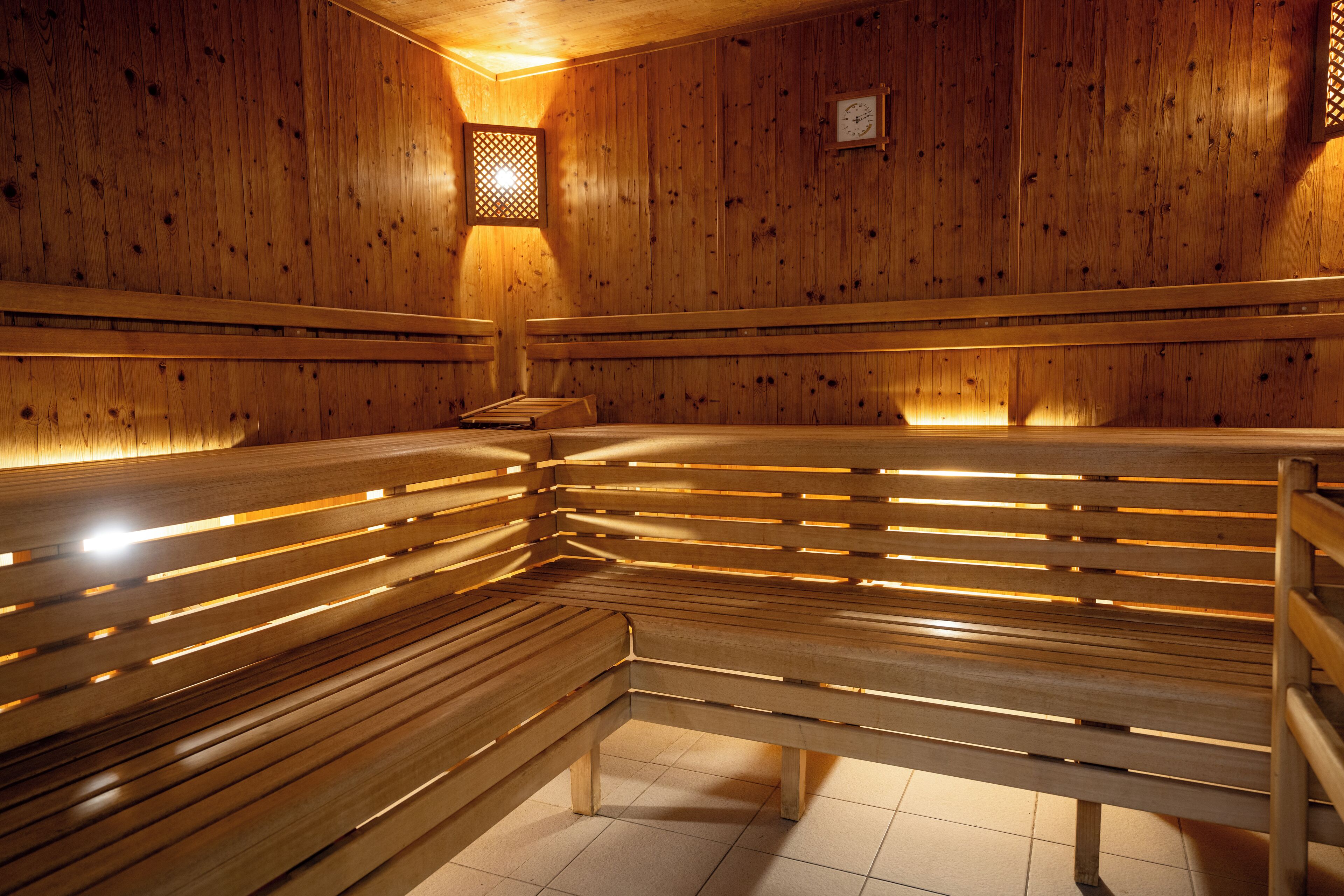 Eine Sauna mit Holzbänken und einem kleinen Fenster.