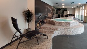 A spa area with a hot tub, seating, and a mural. - AlpenParks Ferienresort Rehrenberg (Viehhofen)