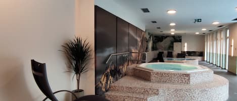 A spa area with a hot tub, seating, and a mural.