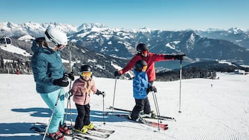 Un grupo de personas en una pista de esquí nevada, con una montaña al fondo.