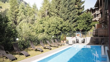 Alberca techada, alberca al aire libre y camastros