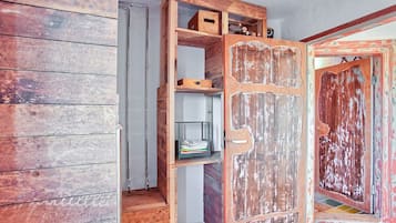 Une pièce dotée d’une porte en bois, d’étagères intégrées et d’un escalier.
