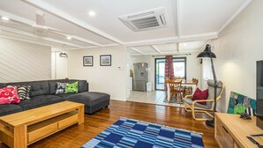 A modern living room with a sofa, coffee table, and a TV stand.