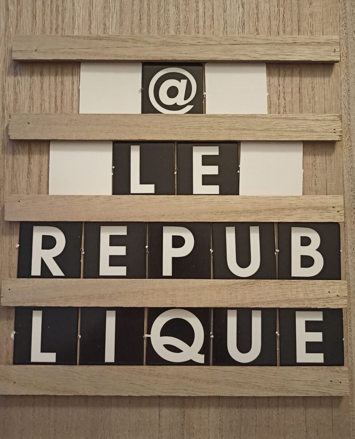 Puinen seinä, jossa on teksti ”LE REPUB LIQUE” ja &-merkki.
