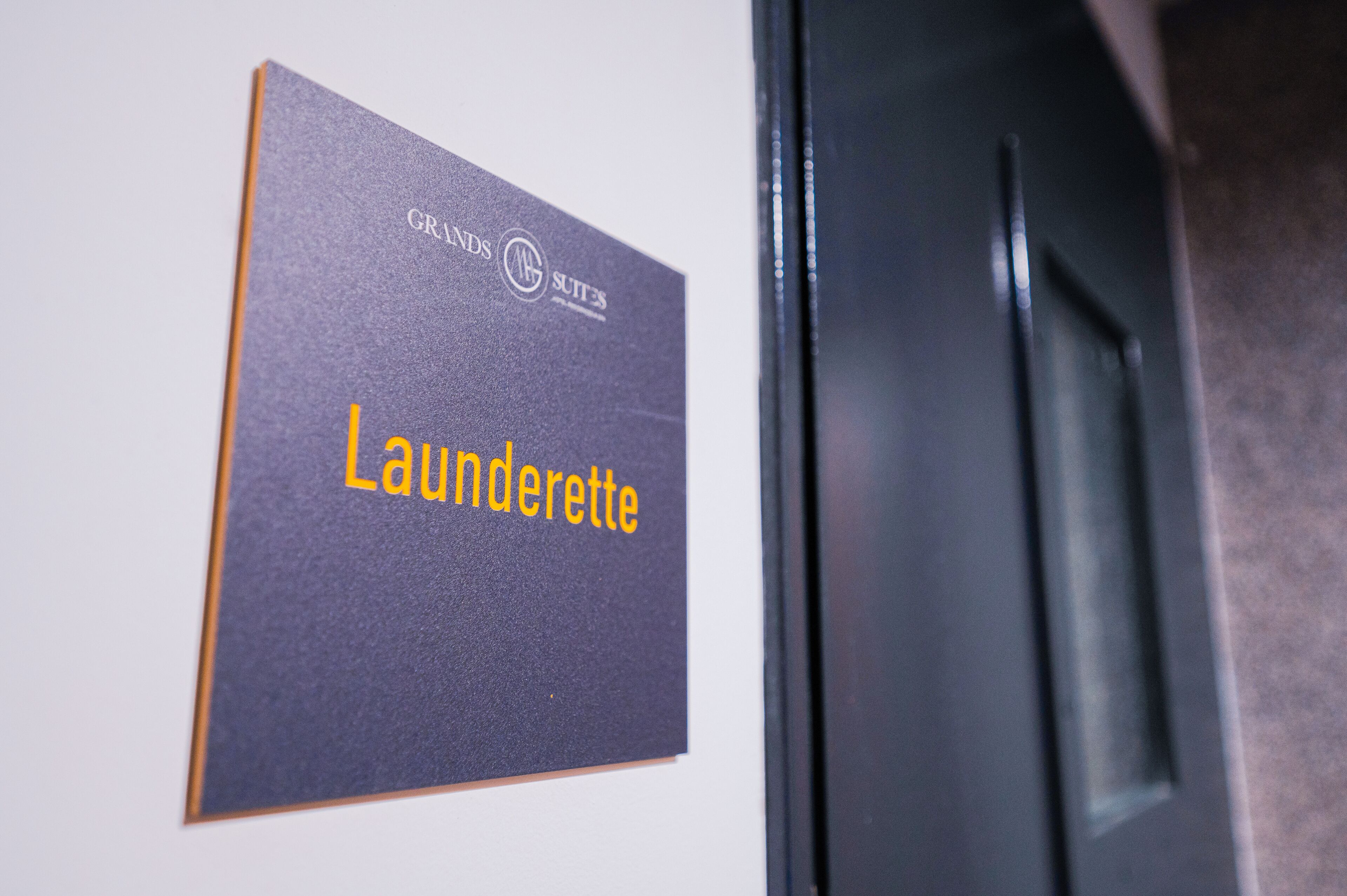 Señal con el texto 'Grands Suites' y 'Lunderette' que indica la ubicación de una suite.