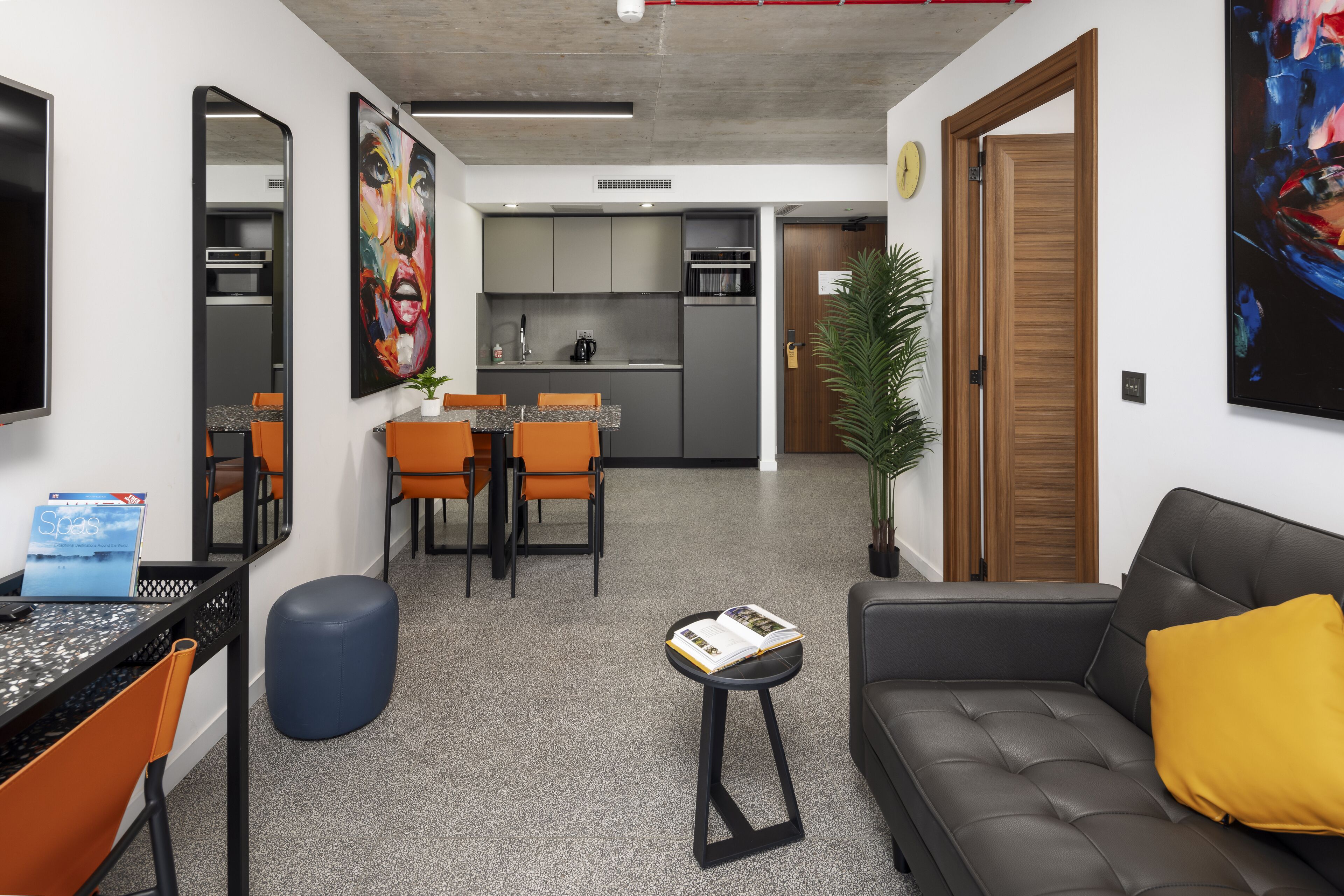 Una sala de estar moderna con un sofá, una mesa de centro y un comedor con sillas y una mesa.